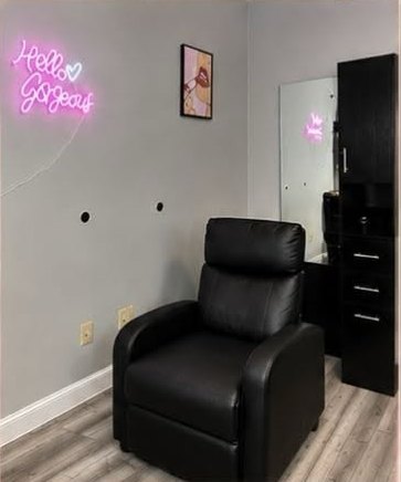 Private suite with reclining chair and Hello Gorgeous neon sign